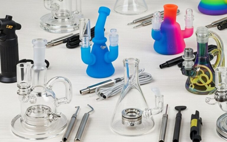 A wide-angle product photograph of a diverse collection of dab rig kits. The display includes various types of rigs, such as clear glass, colorful silicone, and electronic models, each with a banger, a dab tool, a carb cap, and a heating element.